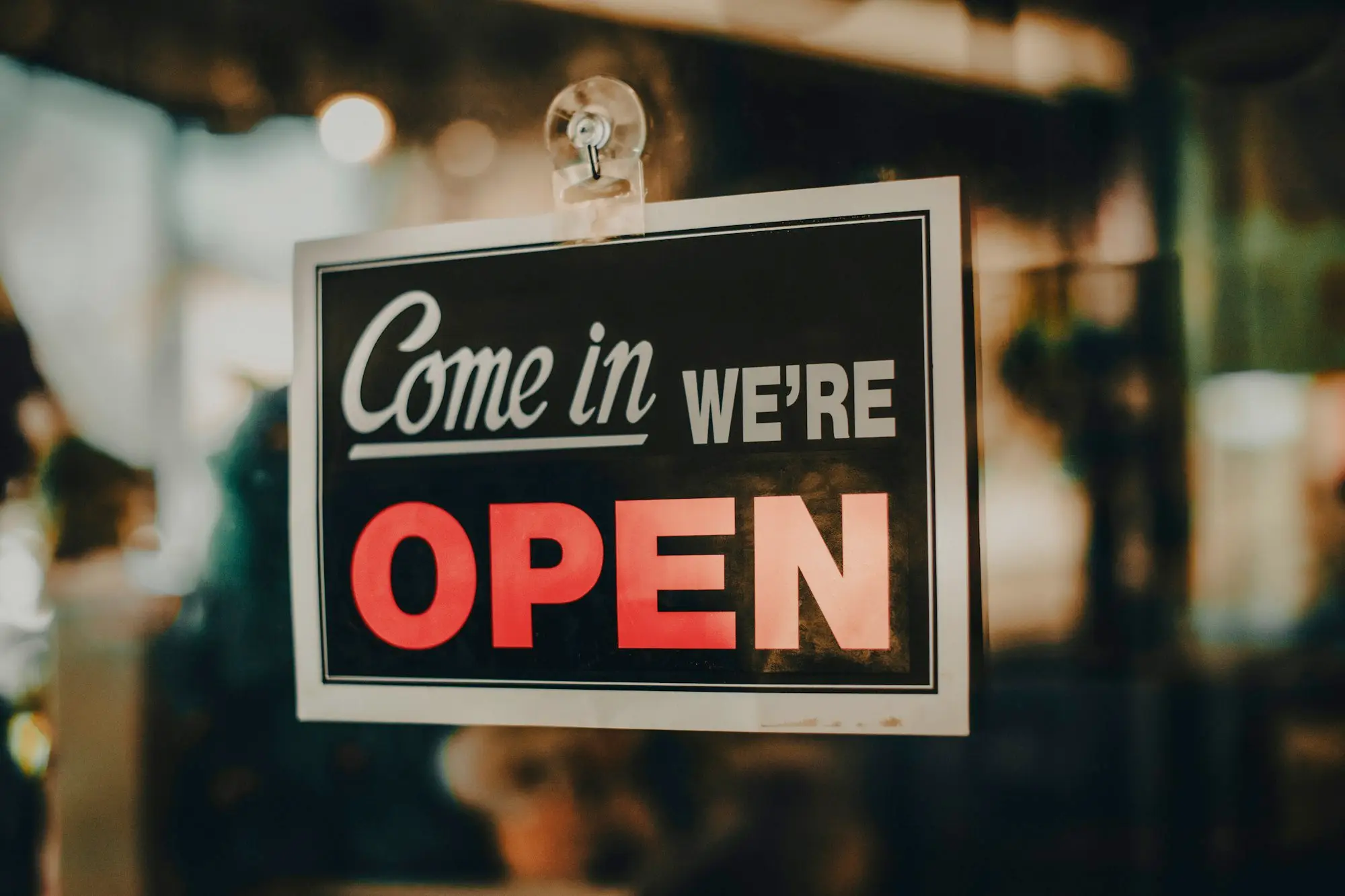 Owner turning the sign on a small Perth shopfront door to open for the day