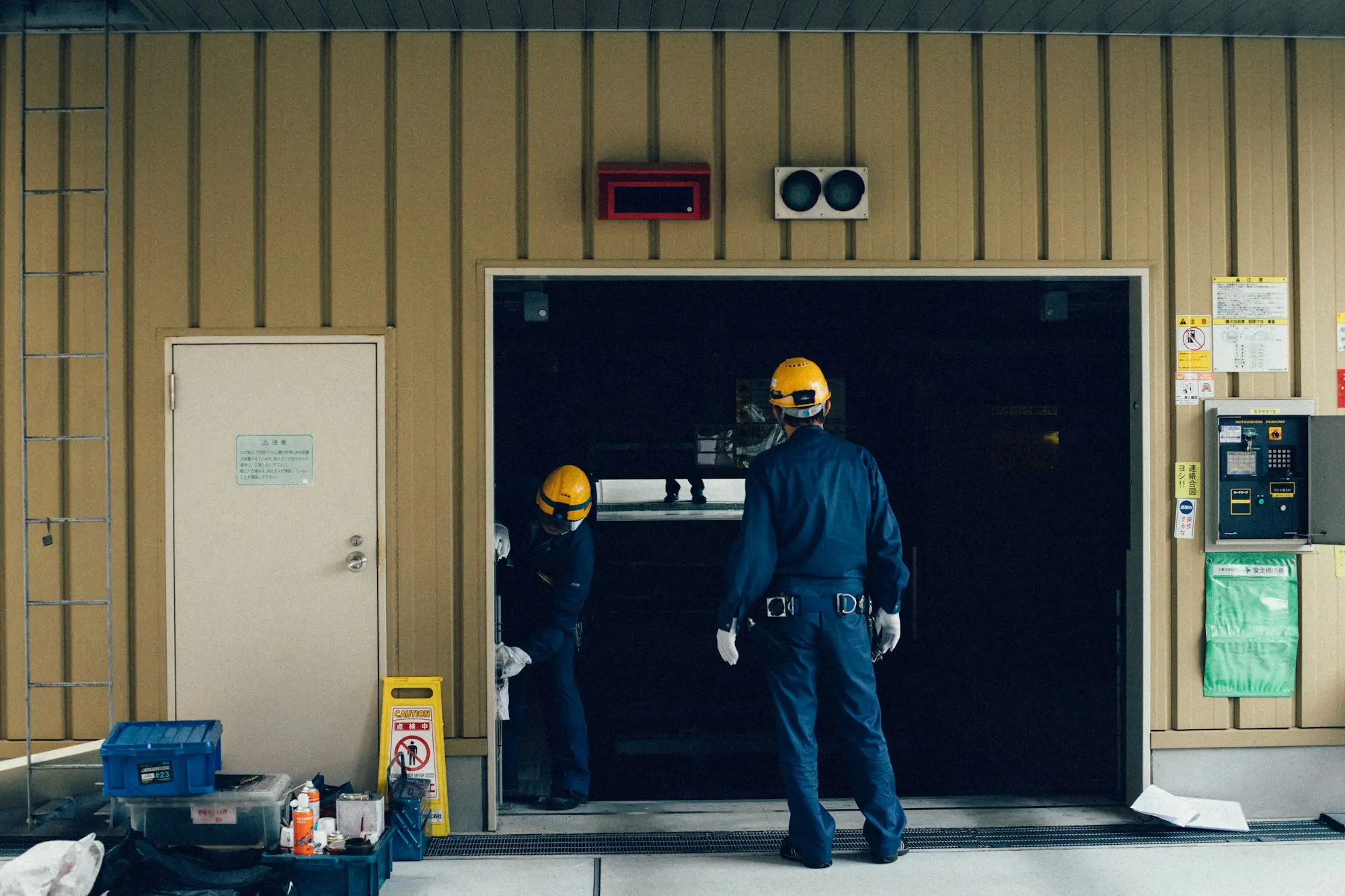 Workshop owner opening a roller door at the start of the day in an Australian industrial estate